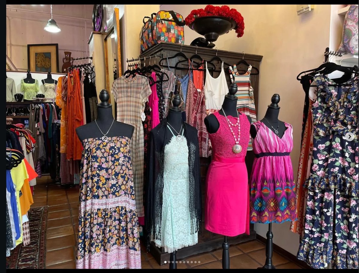 Boutique clothing store interior with mannequins displaying colorful dresses and clothing racks